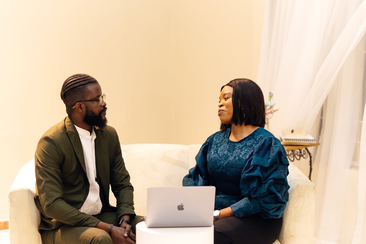 Two colleagues engaged in discussion in a Lagos office setting.