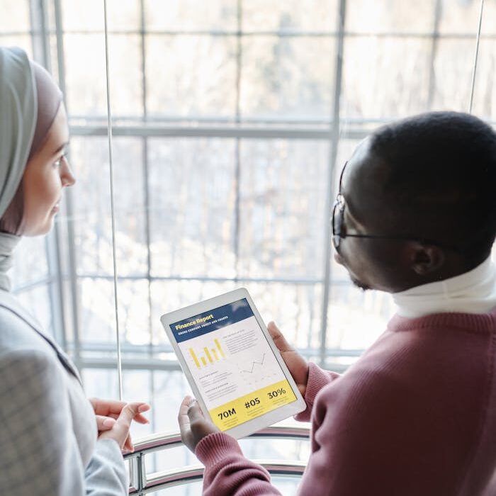 pexels photo 7109163 Two professionals discuss data displayed on a tablet by a window.